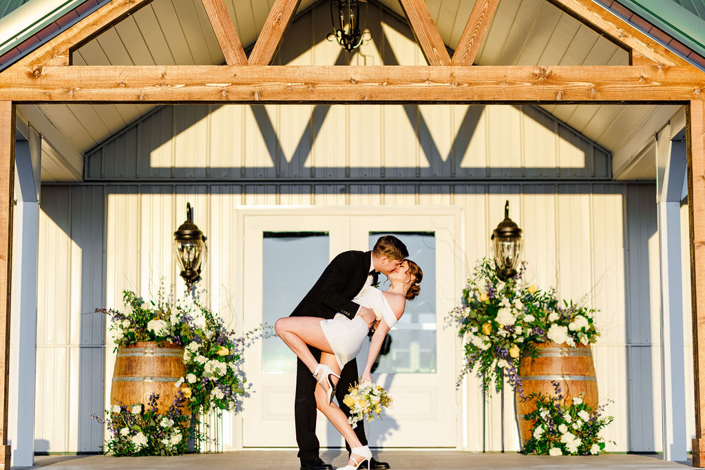 A joyful couple shares a romantic dip outside the wedding venue at Willow and Stone Events, beautifully planned to perfection.